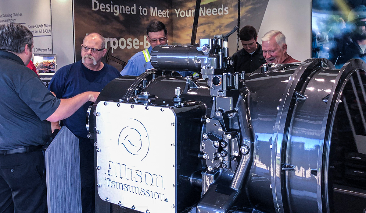 People reviewing an Allison FracTran transmission that is on display