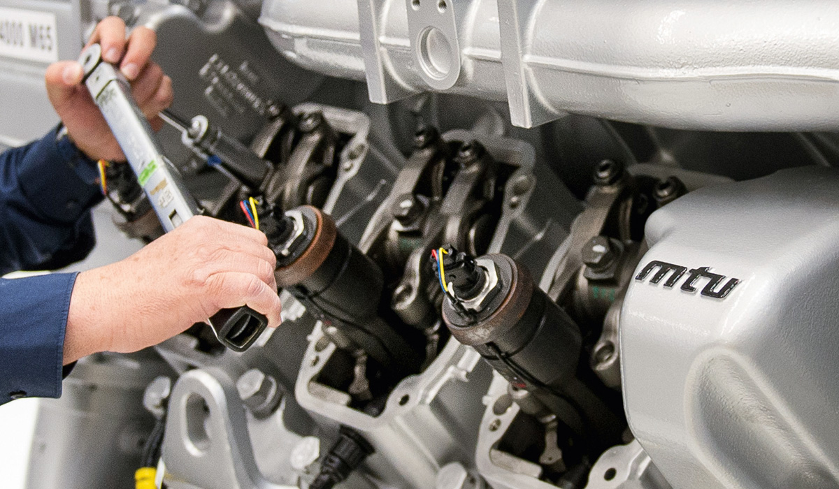 Photo of hands working on mtu engine